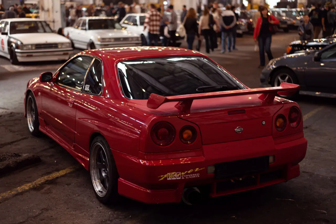 Rød Nissan Skyline set bagfra blandt andre biler